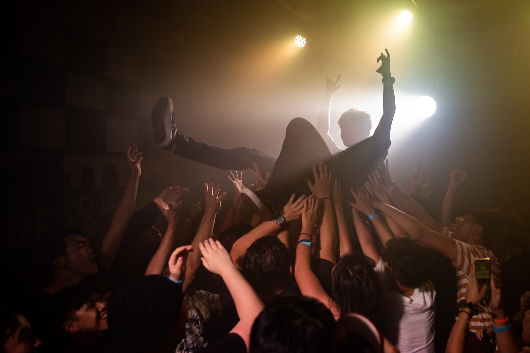Teen crowdsurfing in a concert